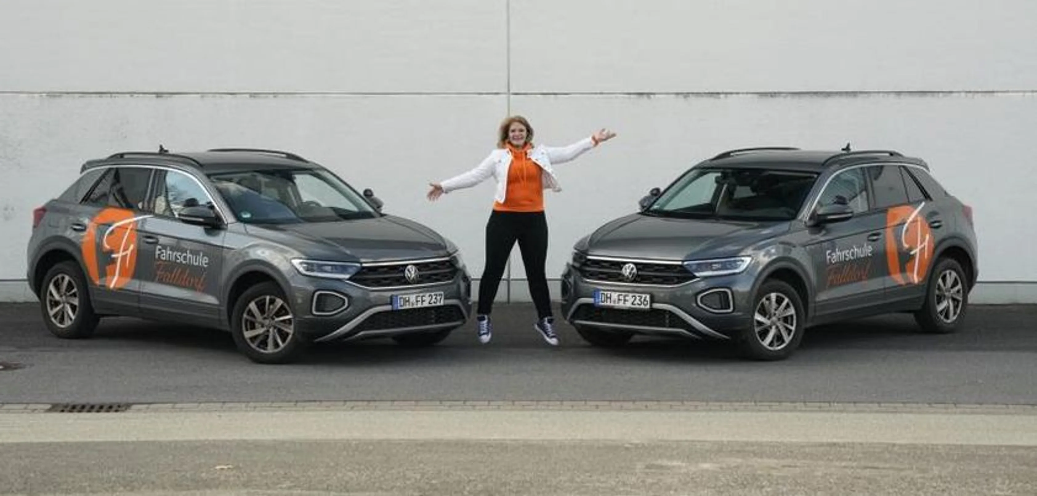 Bianca Falldorf zwischen zwei Fahrzeugen der Fahrschule