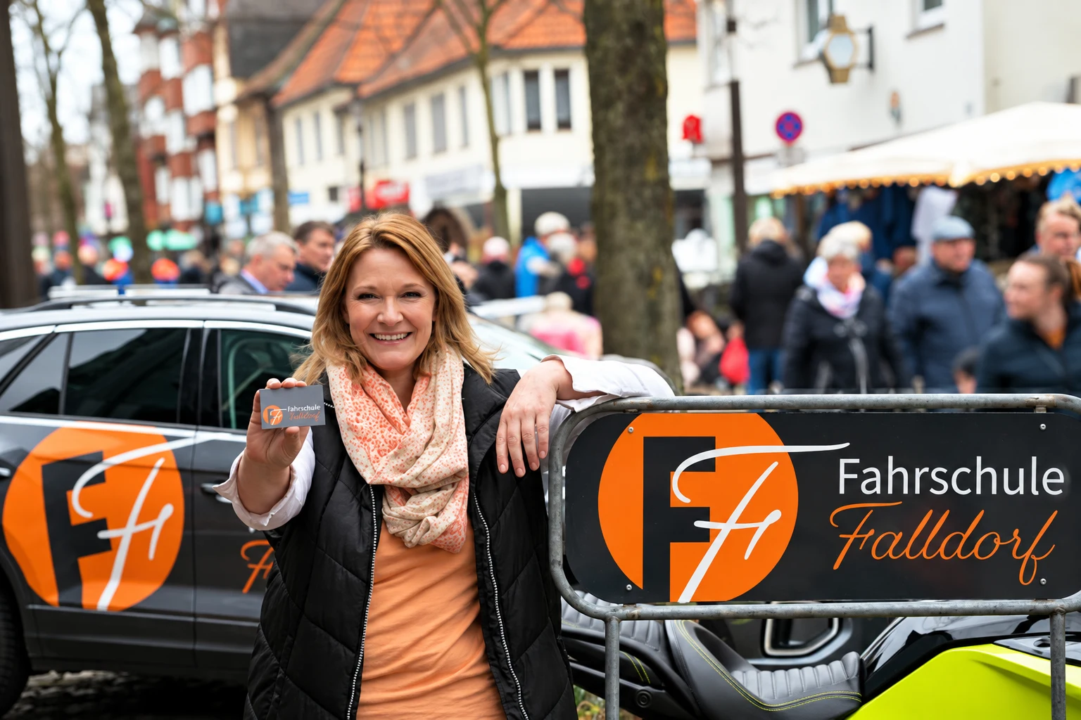 Bianca Falldorf vor einem gebrandeten Fahrzeug ihrer Fahrschule